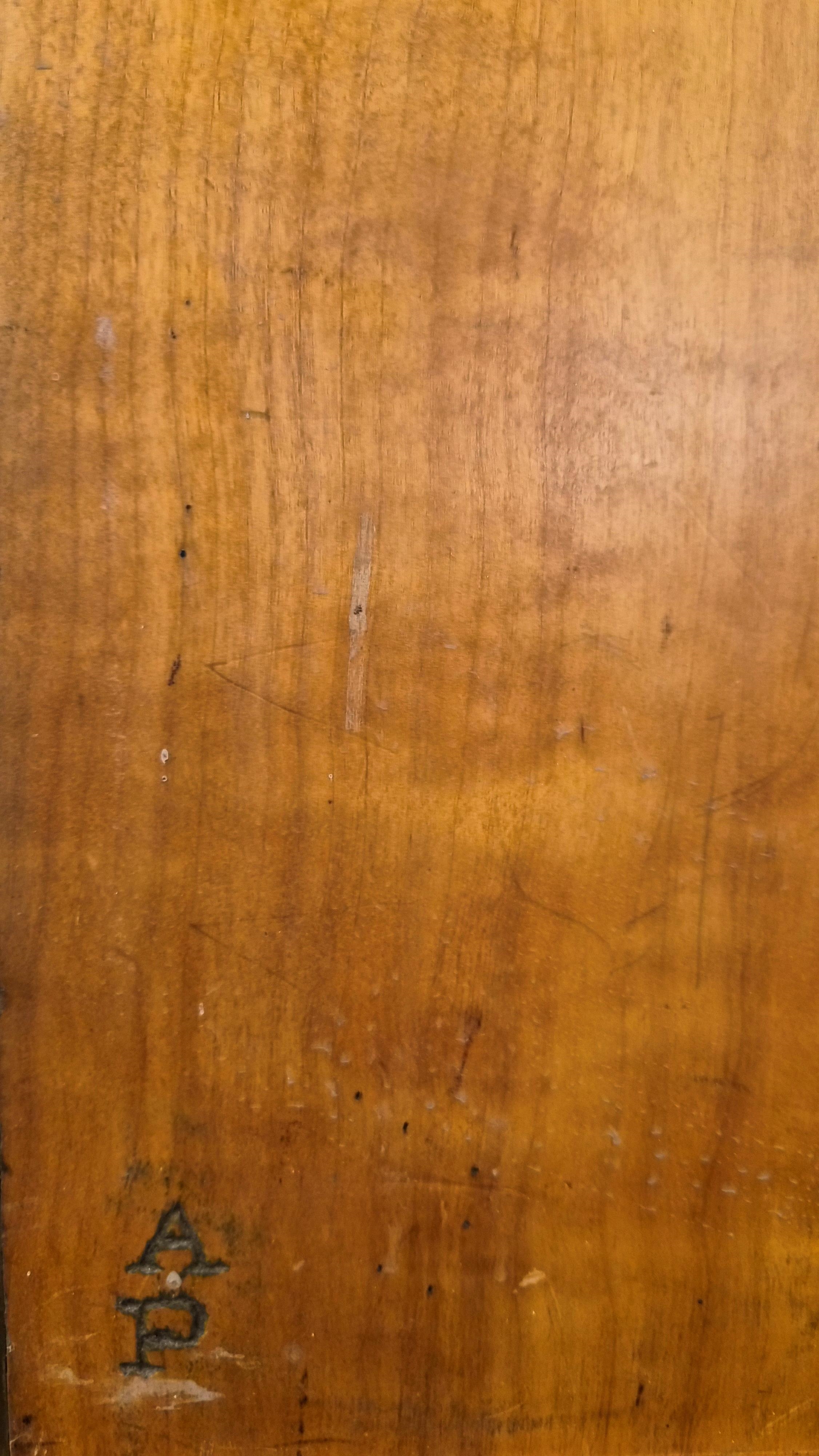 A portrait of a smiling girl in a red shirt against a wooden background.