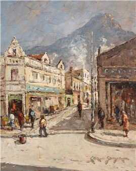 A sun-drenched street scene with a mountain looming in the background.