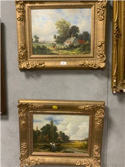 A gallery wall display of two ornate gold-framed landscape paintings depicting pastoral scenes.