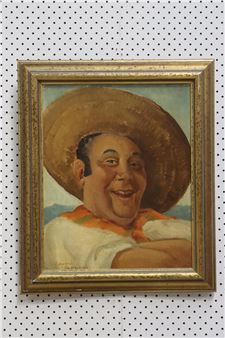 A framed portrait of a smiling man in a sombrero and white shirt.