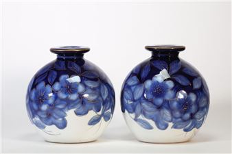 A pair of glossy ceramic vases featuring a blue floral pattern against a white background.