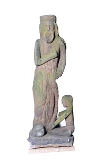 A weathered stone sculpture of a standing figure with a smaller seated figure at its base.