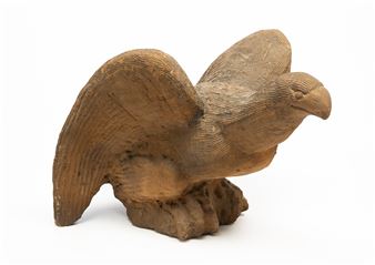 A carved wooden sculpture of a bird in flight.