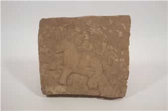 A weathered stone relief depicting a seated figure surrounded by foliage.