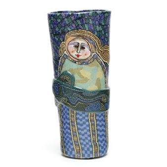 A ceramic vase featuring a stylized figure with mosaic-like patterns and bold blue tones.