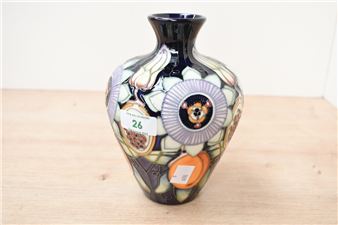 A decorative ceramic vase featuring a stained-glass style floral and fruit pattern.