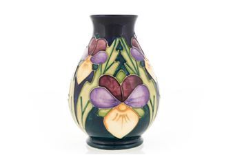 A ceramic vase featuring a stylized floral design with purple and yellow pansies against a dark background.