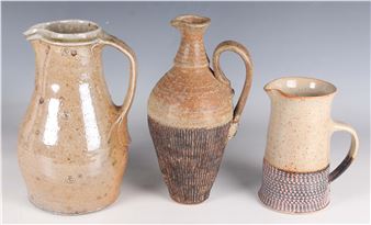 A trio of handcrafted ceramic pitchers and jugs with varied shapes, textures, and earthy glazes.