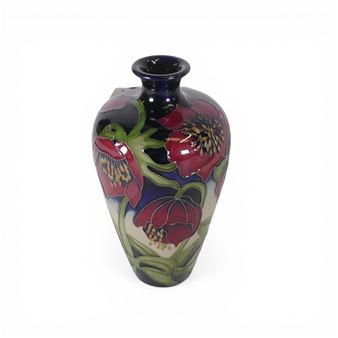 A glossy ceramic vase featuring a vibrant floral design against a deep blue background.