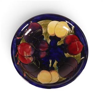 A ceramic bowl featuring a vibrant, stylized fruit arrangement.