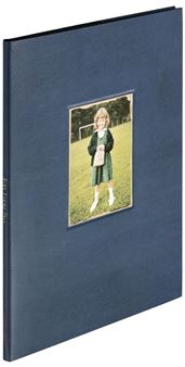 A blue photo album featuring a vintage photograph of a child in a school uniform.