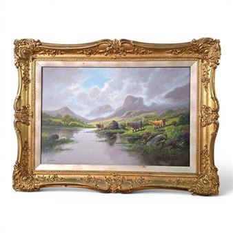 A pastoral landscape painting in an ornate gold frame depicting cattle grazing near a river with distant mountains.
