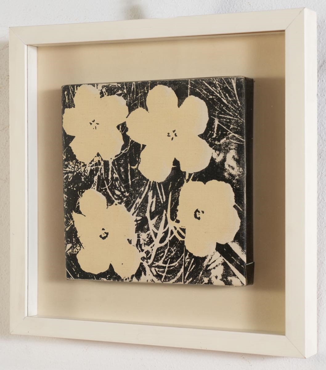 A bold black-and-white print featuring four large, stylized flowers against a textured background.
