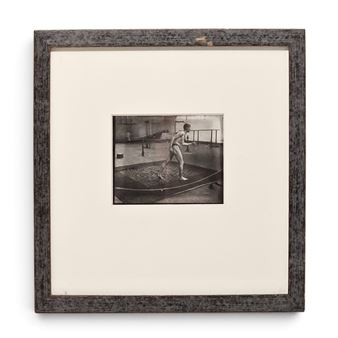 A framed black-and-white photograph of a figure in motion inside a boat.