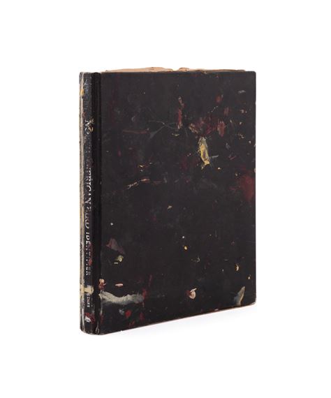 A worn, dark-bound book with visible signs of age and use.