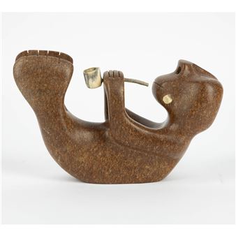 A stylized brown wooden sculpture of a figure holding a pipe, featuring smooth curves and a speckled texture.