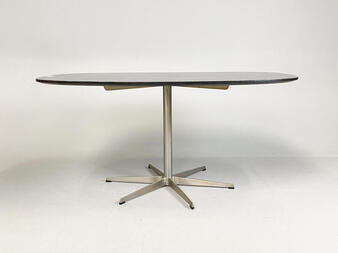 A sleek, modern dining table with a star-shaped base and oval top.