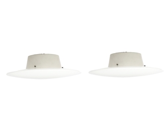 A minimalist product shot of two identical white ceramic lamp fixtures against a stark background.