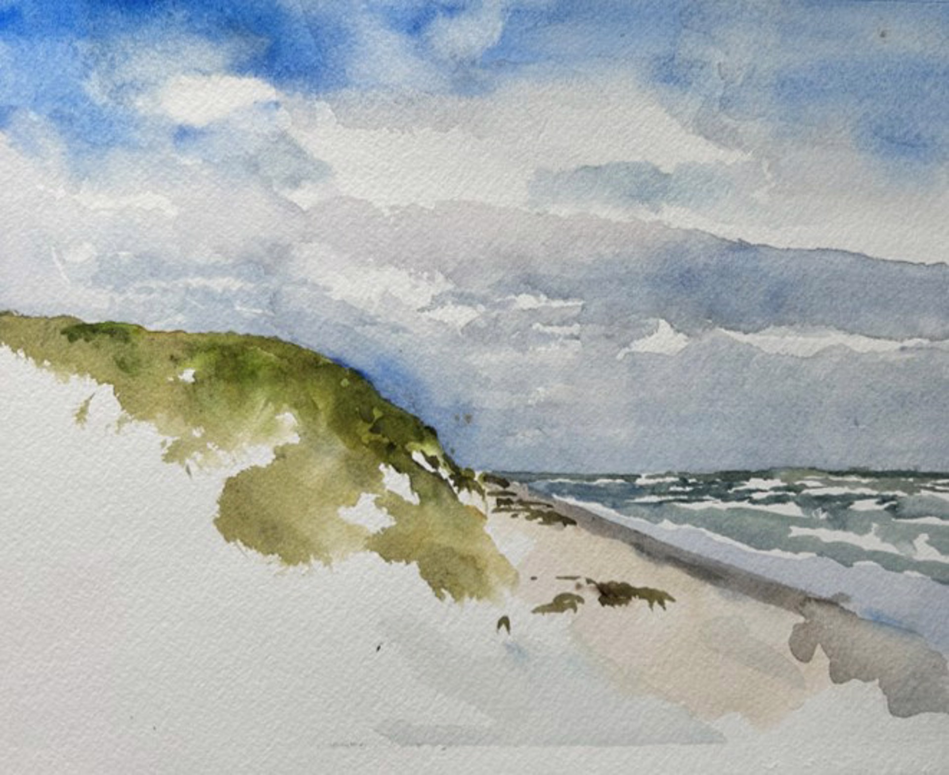 A watercolor seascape of a sandy beach with a green dune under a cloudy sky.