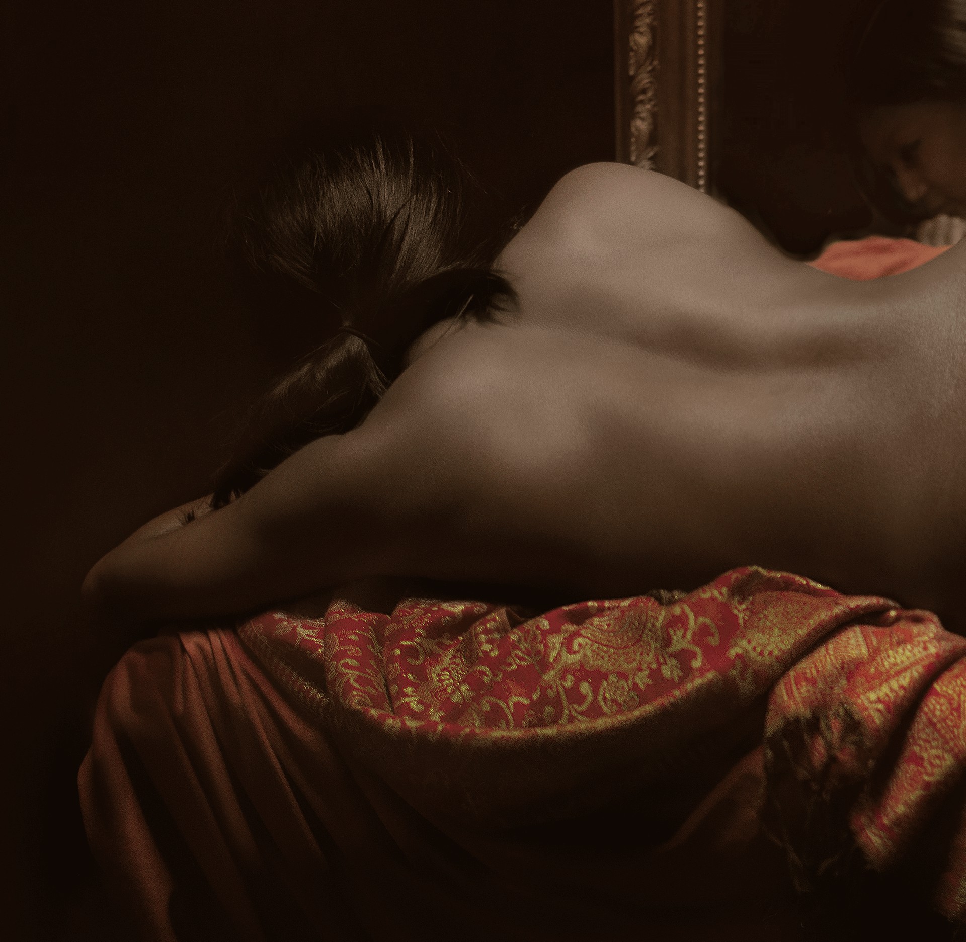 A dramatic, classical-style painting of a reclining figure in rich fabrics.