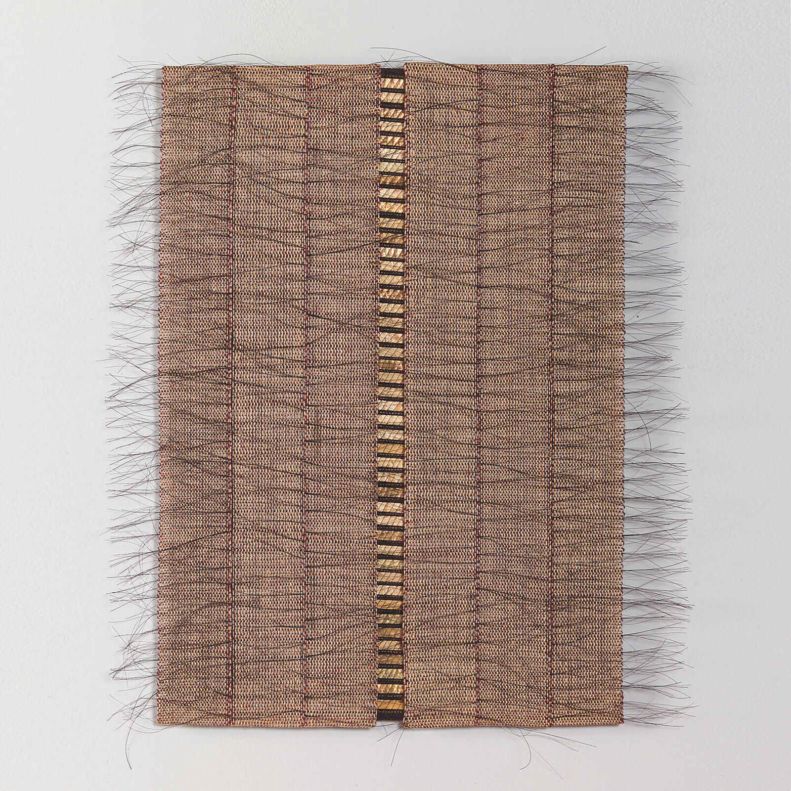 A rectangular textile piece featuring a central metallic strip and frayed edges.