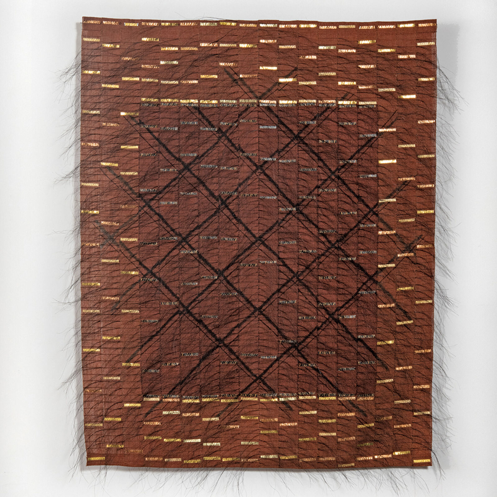 A textured textile artwork featuring a geometric diamond pattern on a brown background with frayed edges.
