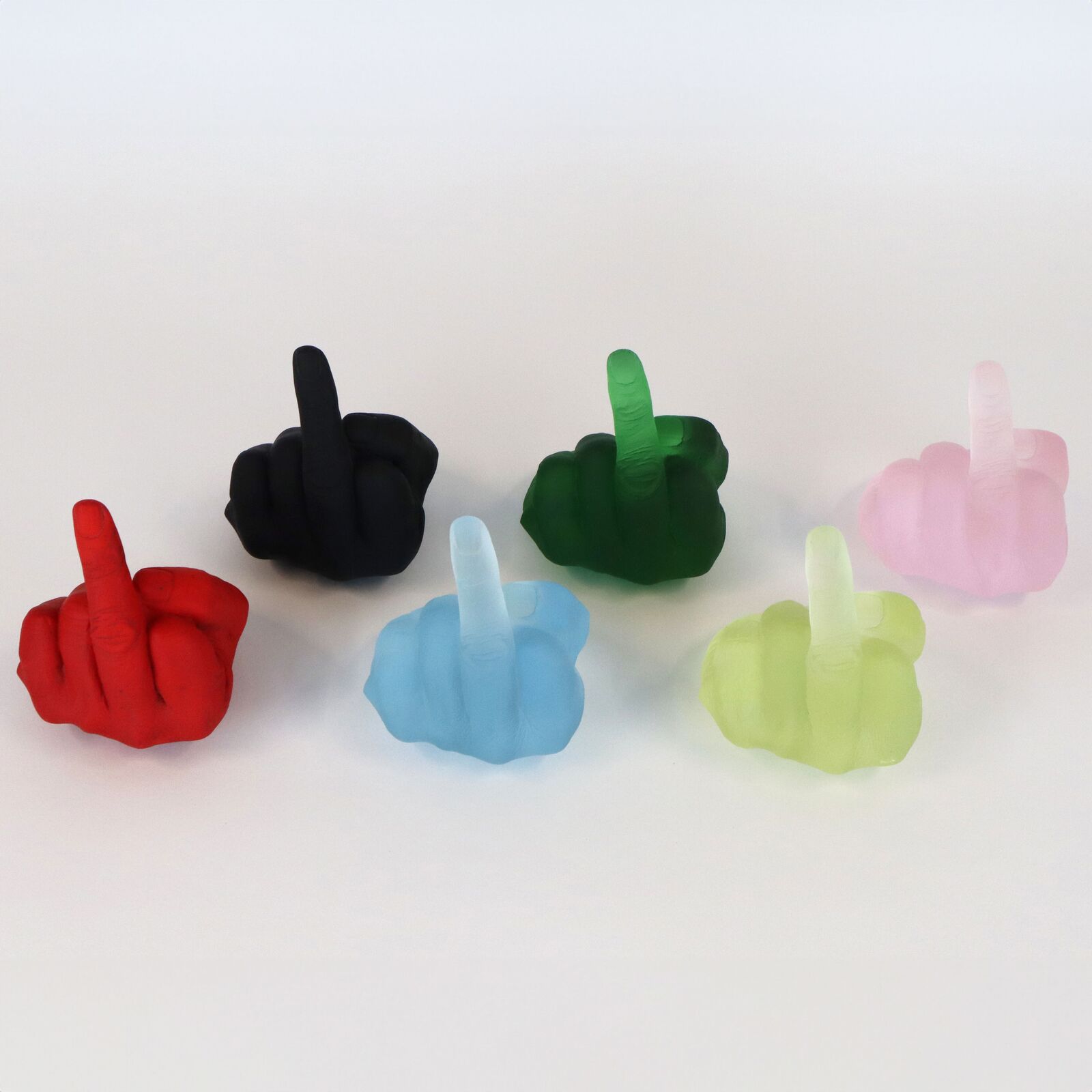 A row of six translucent, colorful hand sculptures in the middle finger gesture.