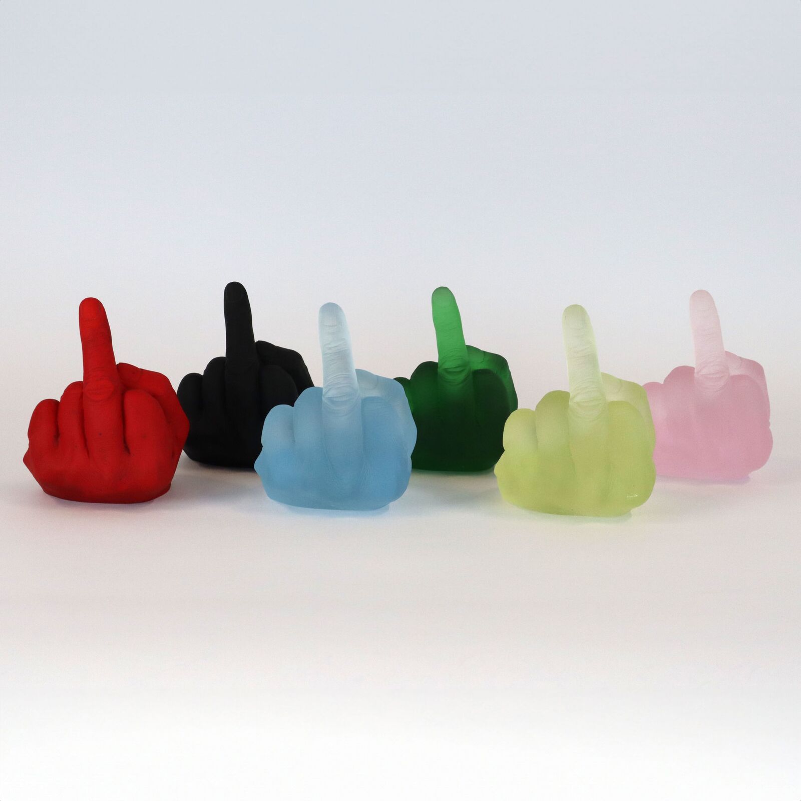 A row of six translucent, colorful hand sculptures in the middle finger gesture.