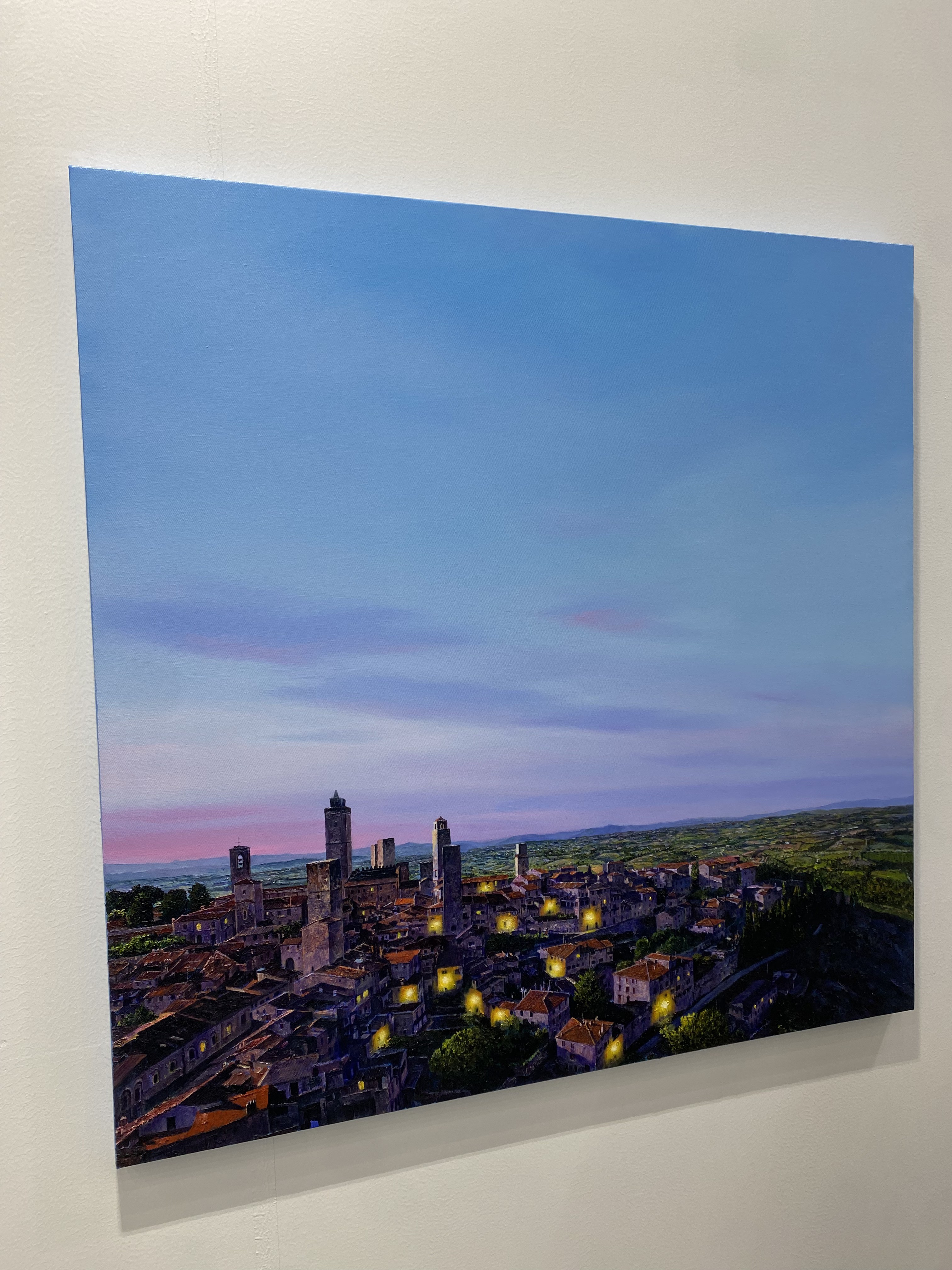 A painting of a city at dusk with a blue sky.