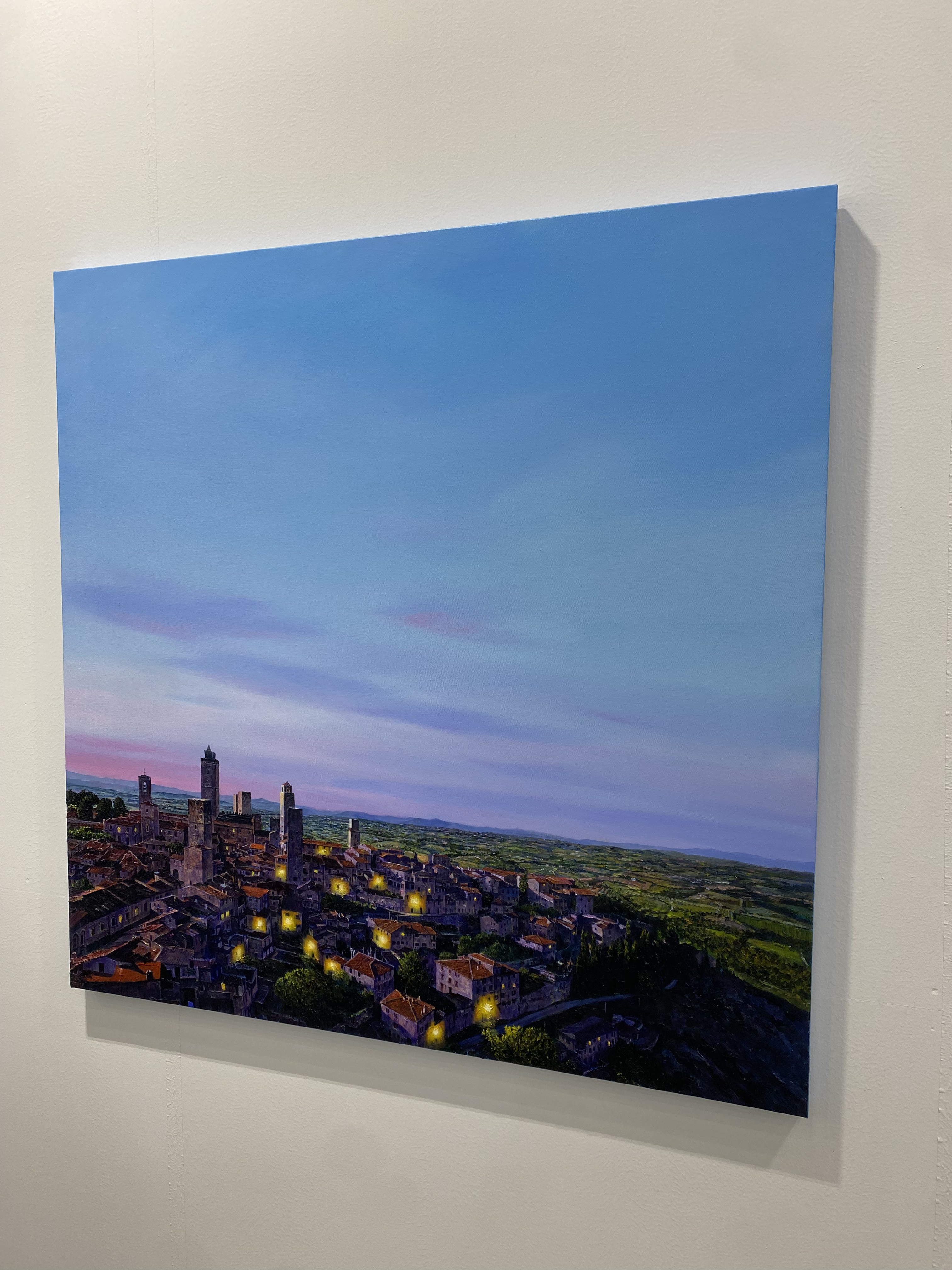 A painting of a city at dusk with a blue sky.