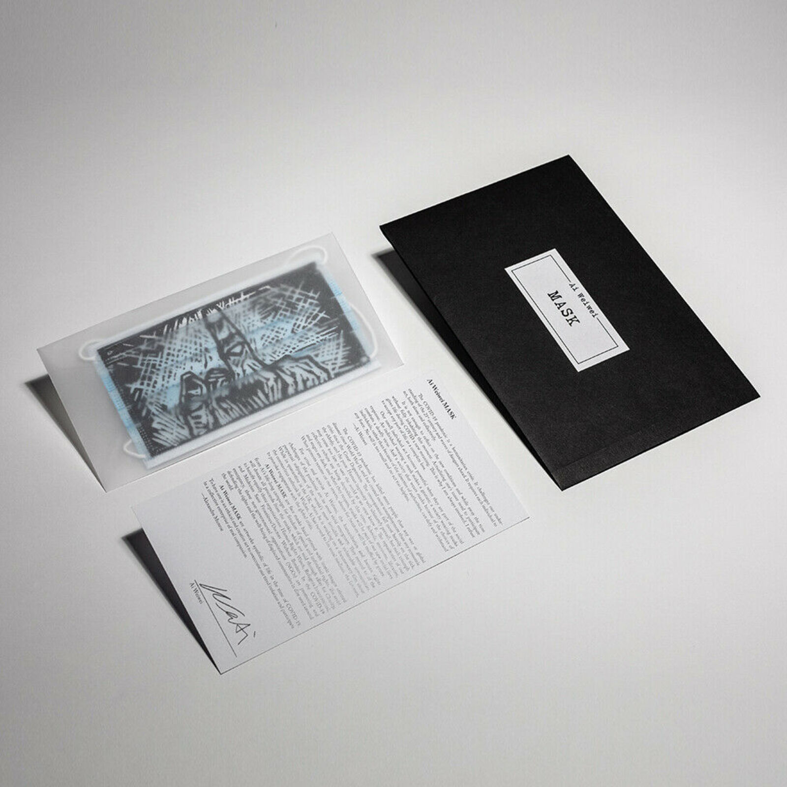 A black and white business card and envelope on a white surface.