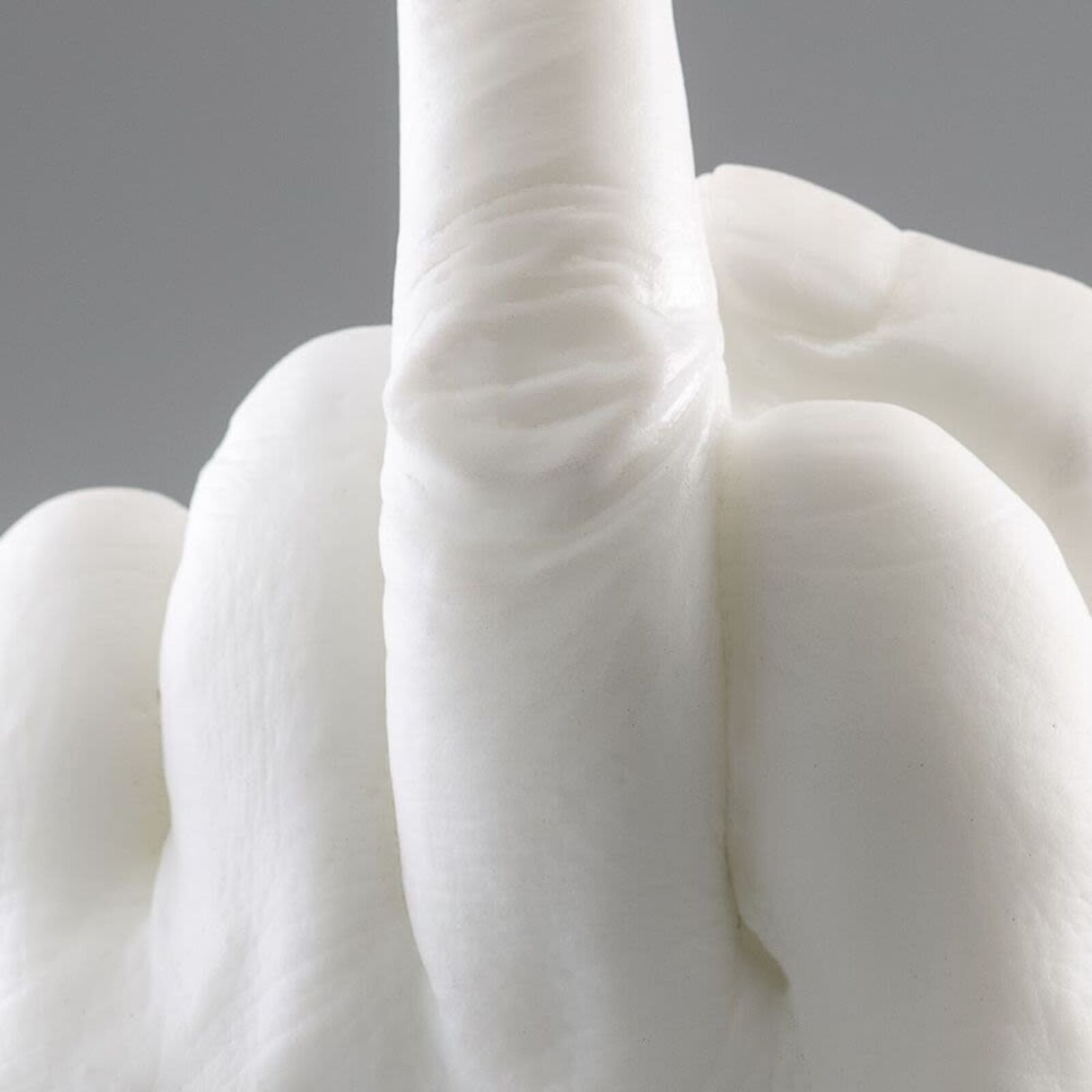 A white sculpture of a hand making a peace sign.
