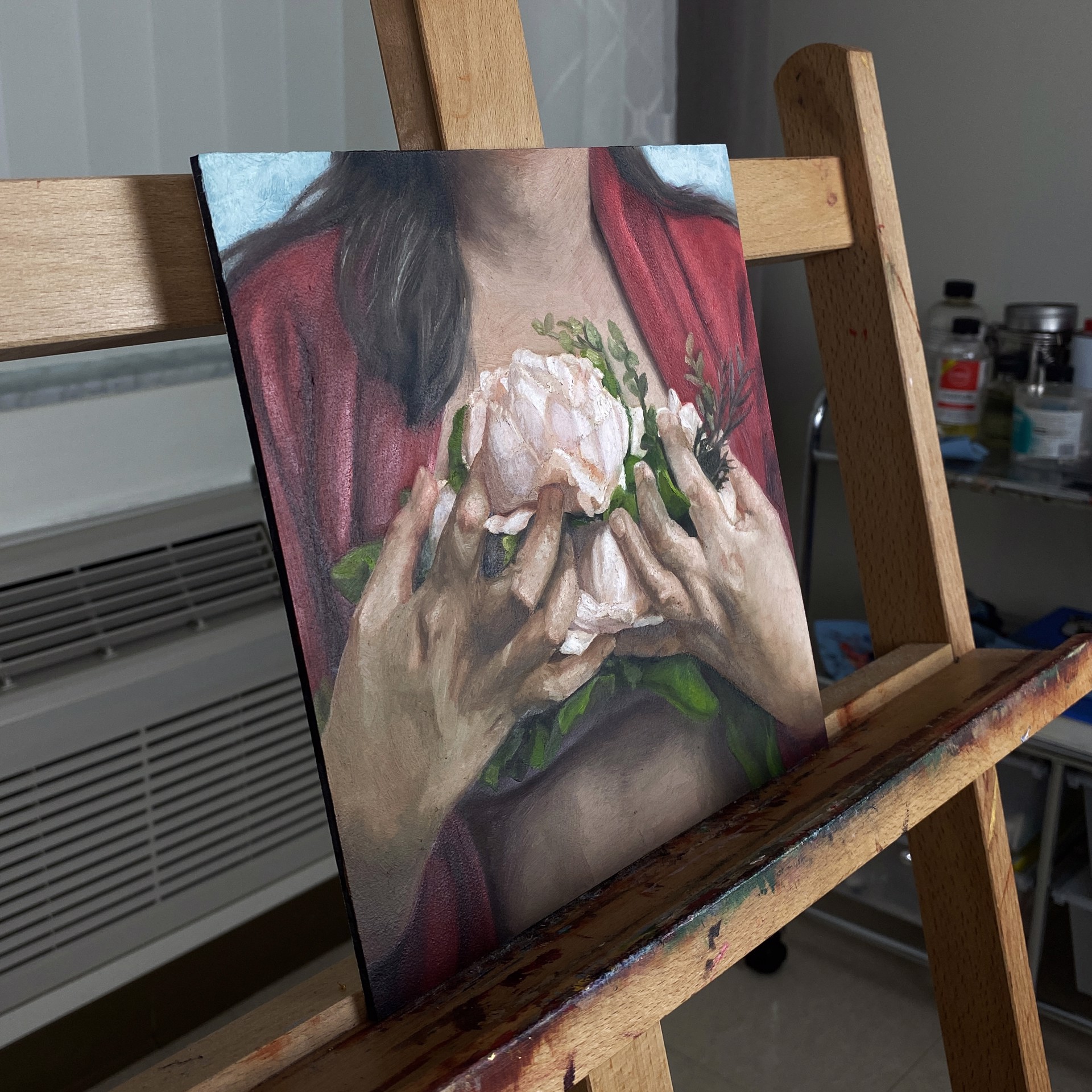 A painting of a woman holding a flower in her hands.