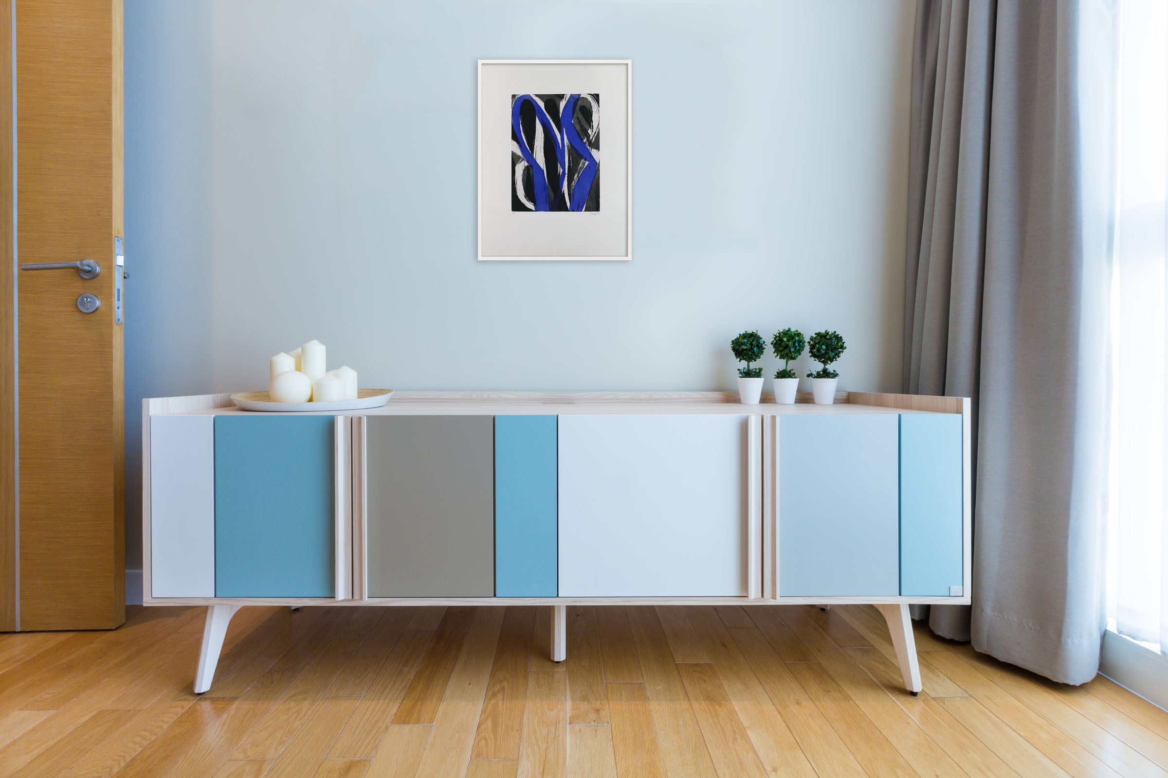 A blue and black abstract painting on a white wall.