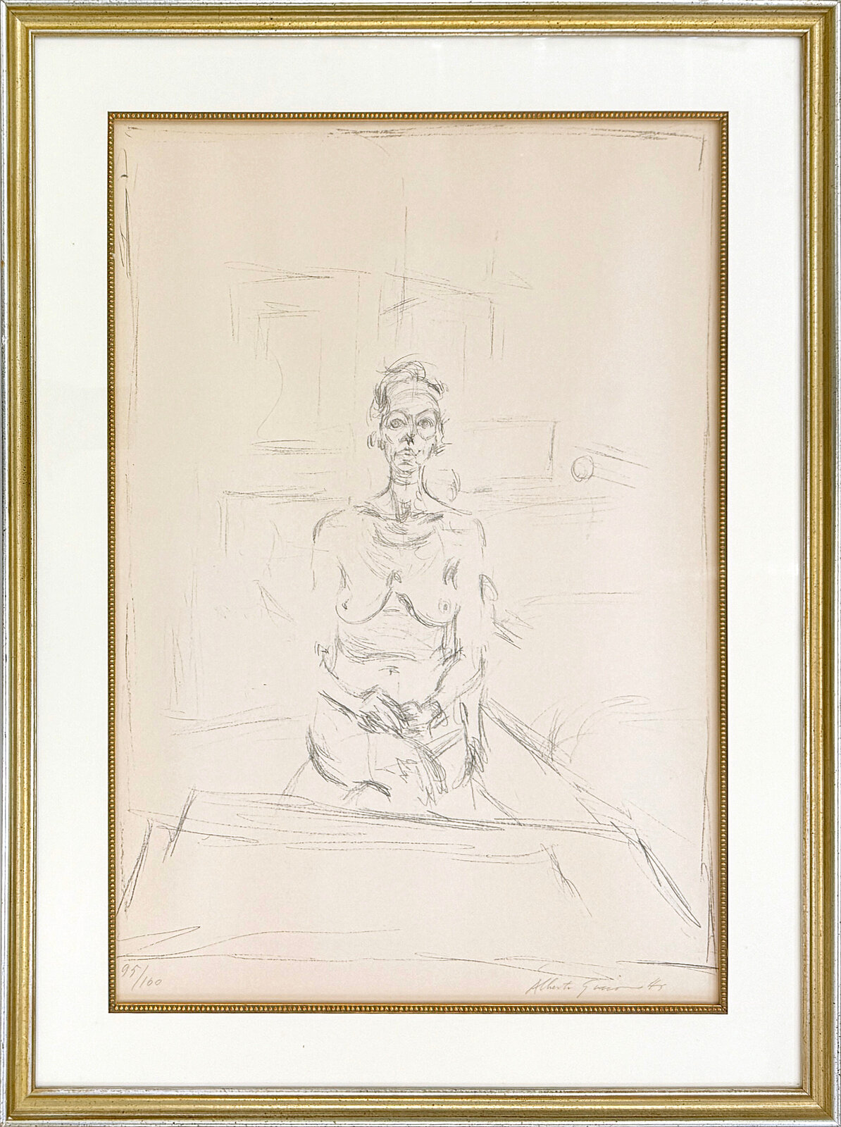 A graphite sketch of a seated nude figure in a studio setting.
