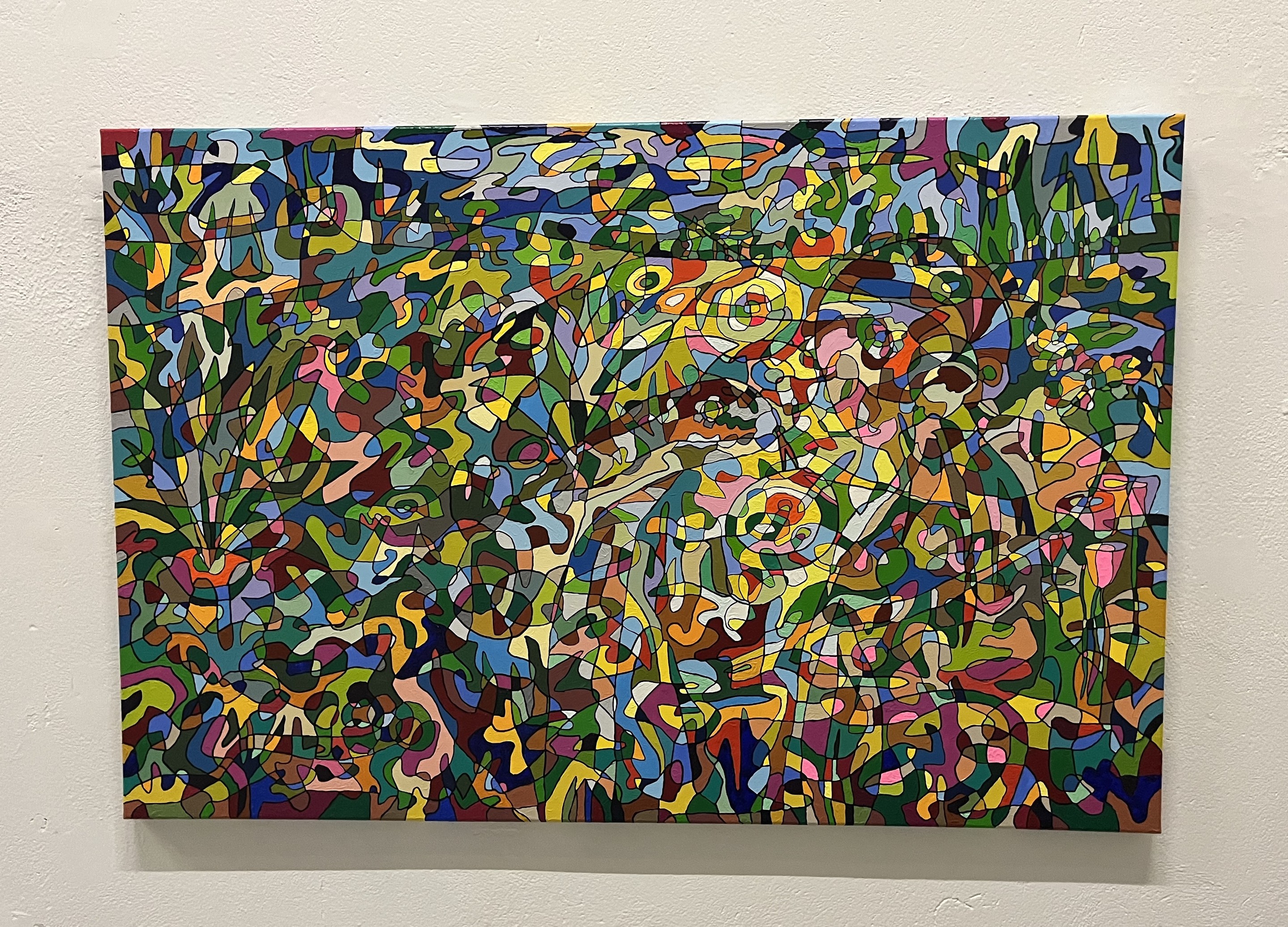 A colorful painting hanging on a wall in a room.