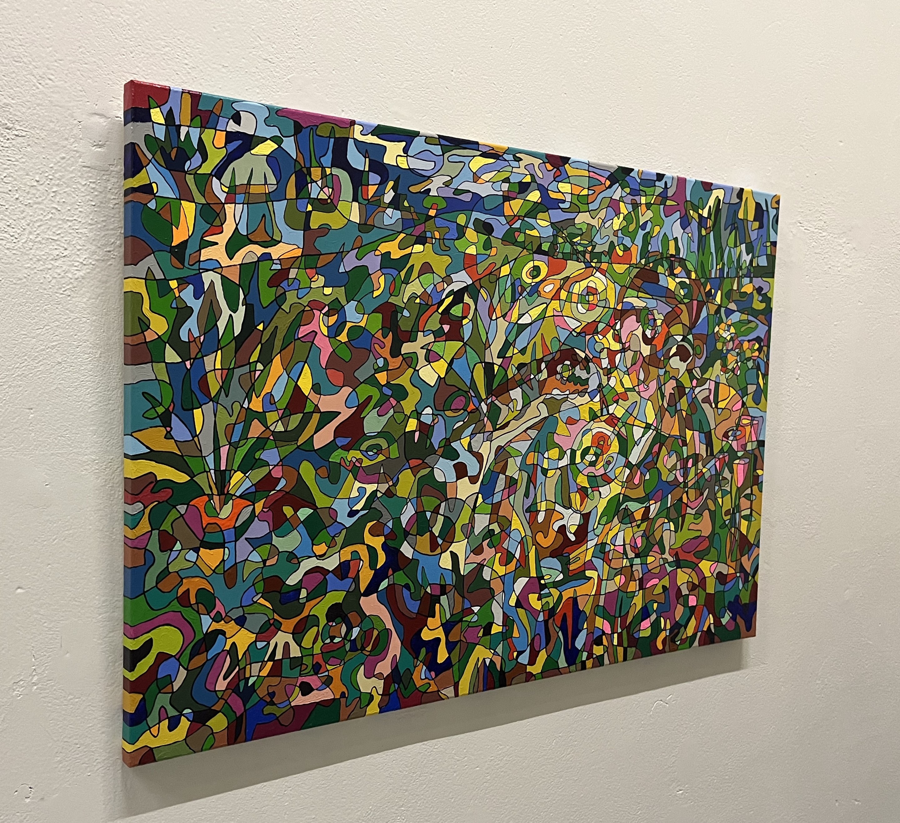 A colorful painting hanging on a wall in a room.