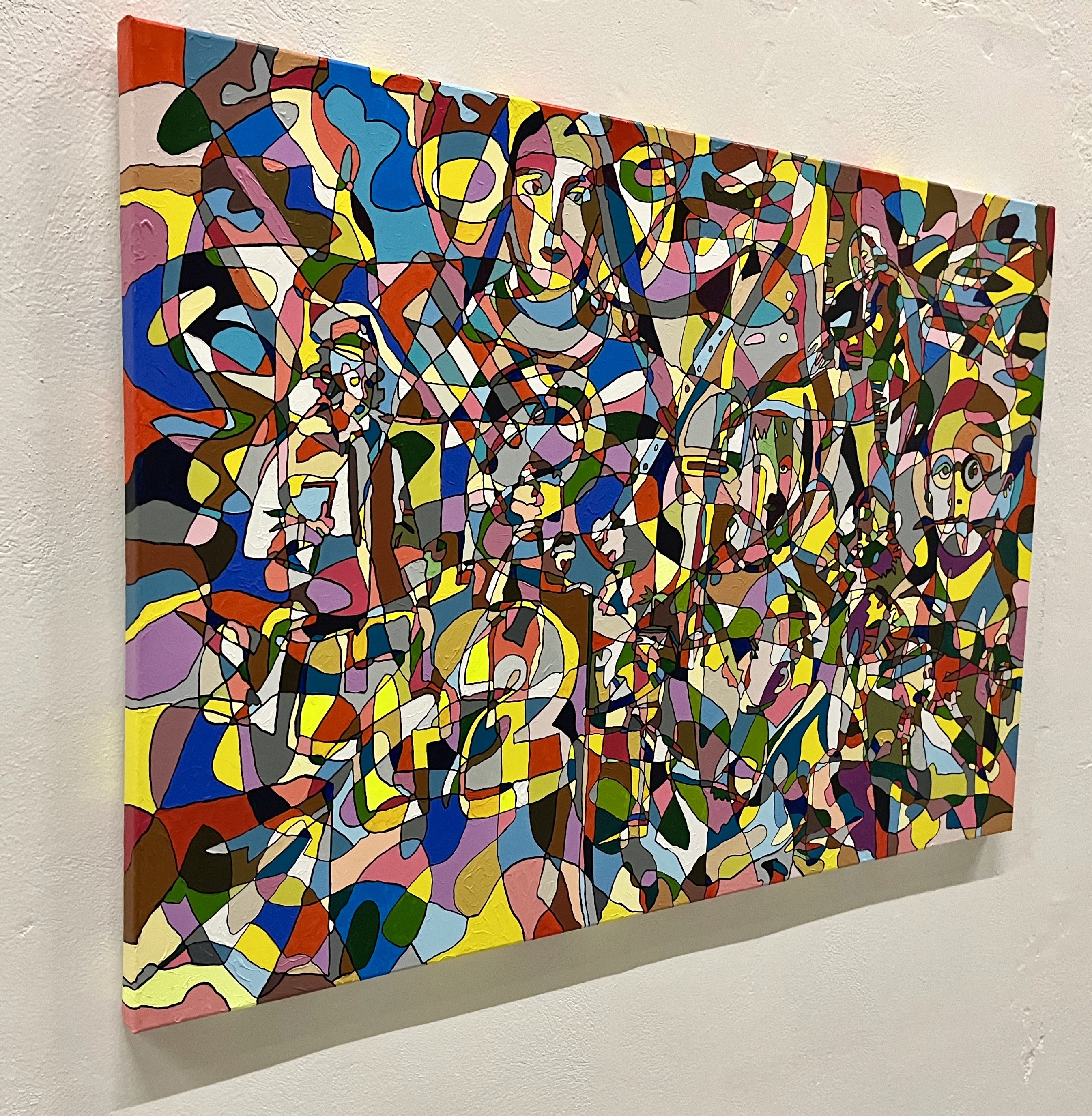 A colorful painting on a white wall in a room.