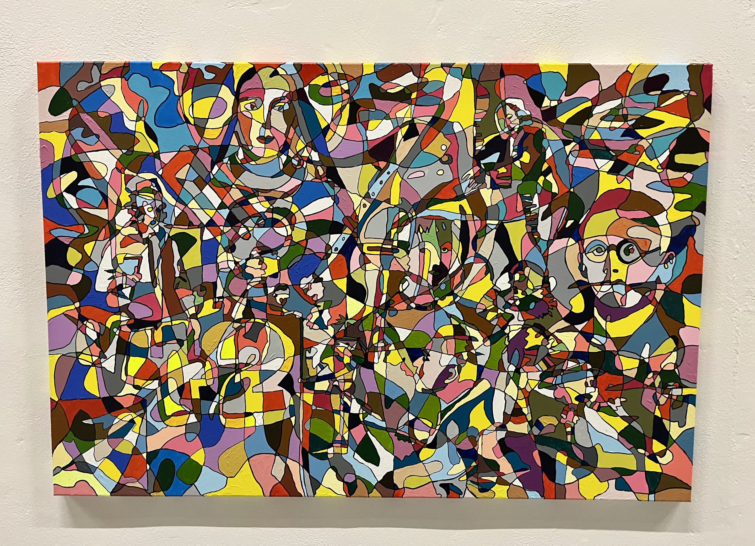 A colorful painting on a white wall in a room.