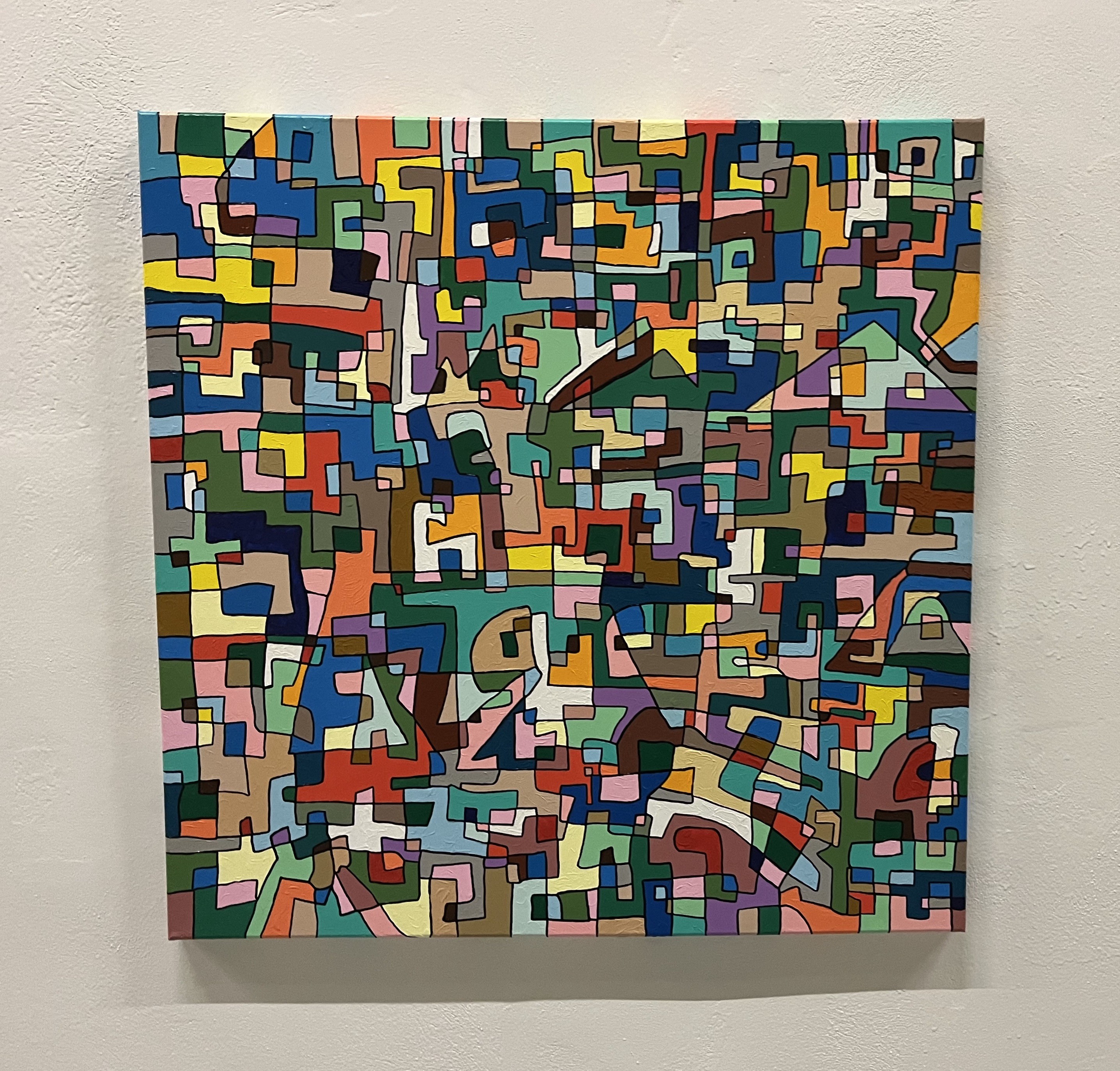 A painting on a wall in a room with a white wall.