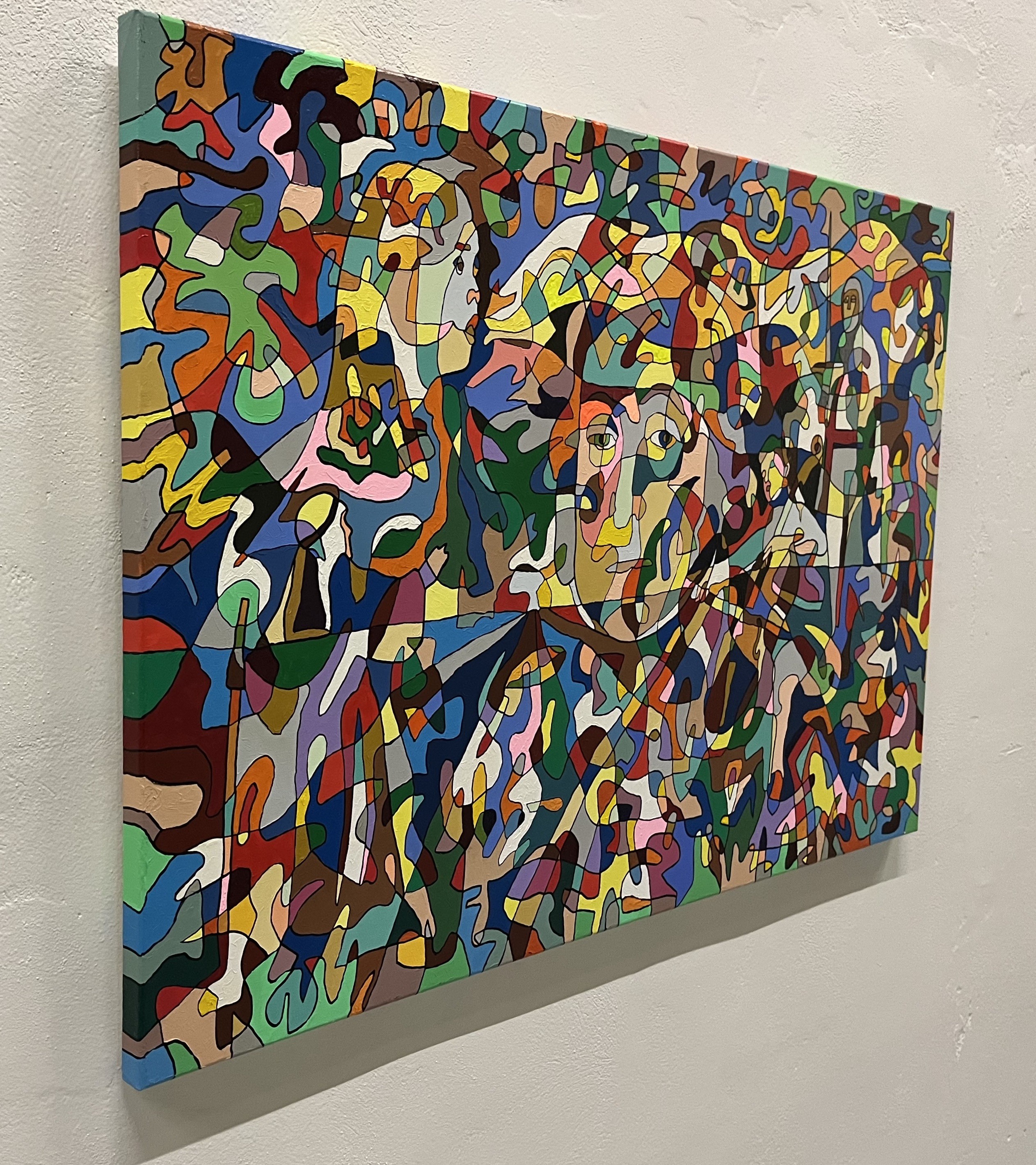 A colorful painting on a white wall in a room.
