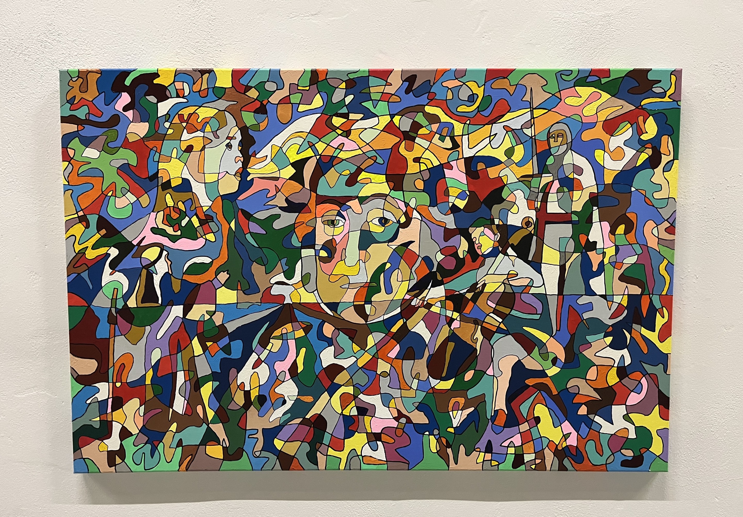 A colorful painting on a white wall in a room.