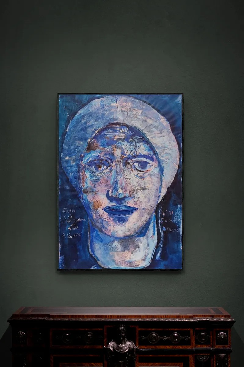 A textured blue portrait of a face with an ornate halo, rendered in expressive brushstrokes.