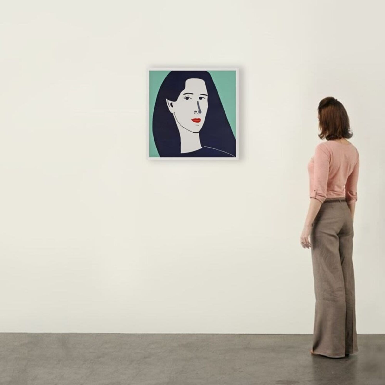 A woman standing in front of a painting on a wall.