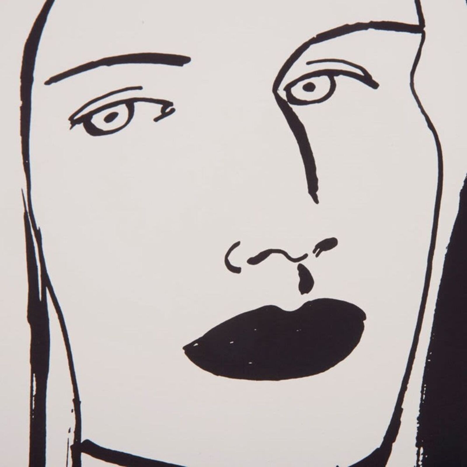 A black and white drawing of a woman's face on a wall.