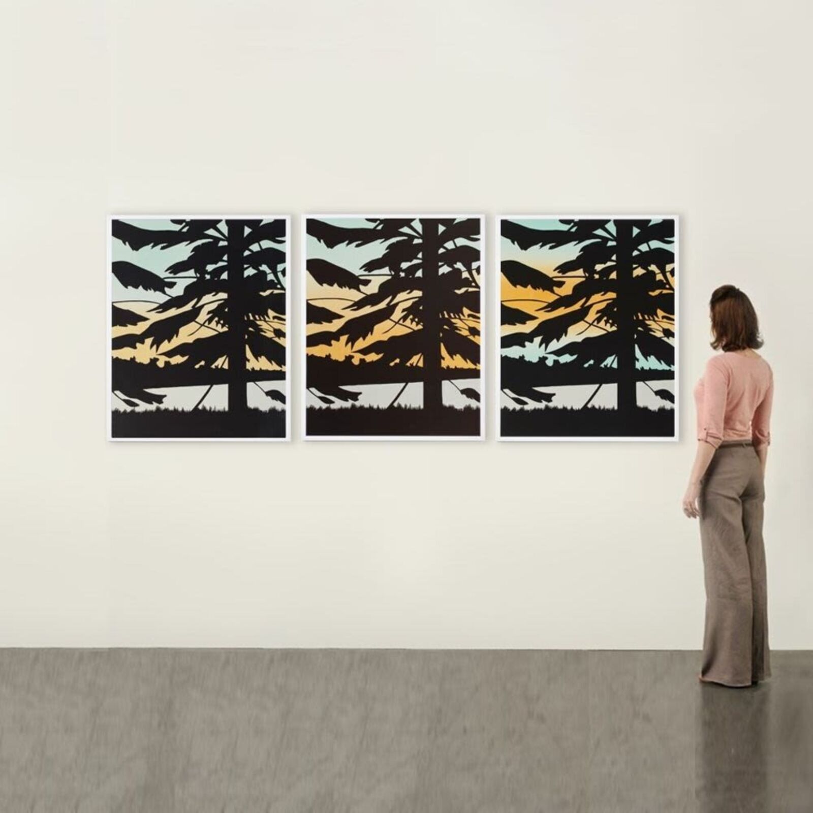 A set of three prints of a sunset with trees in the background.