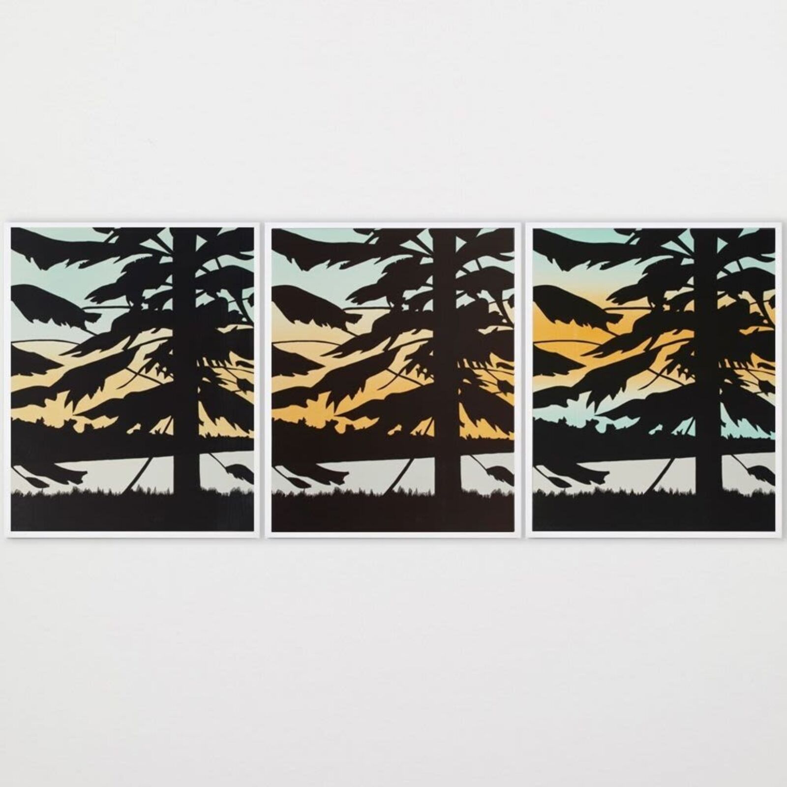 A set of three prints of a sunset with trees in the background.