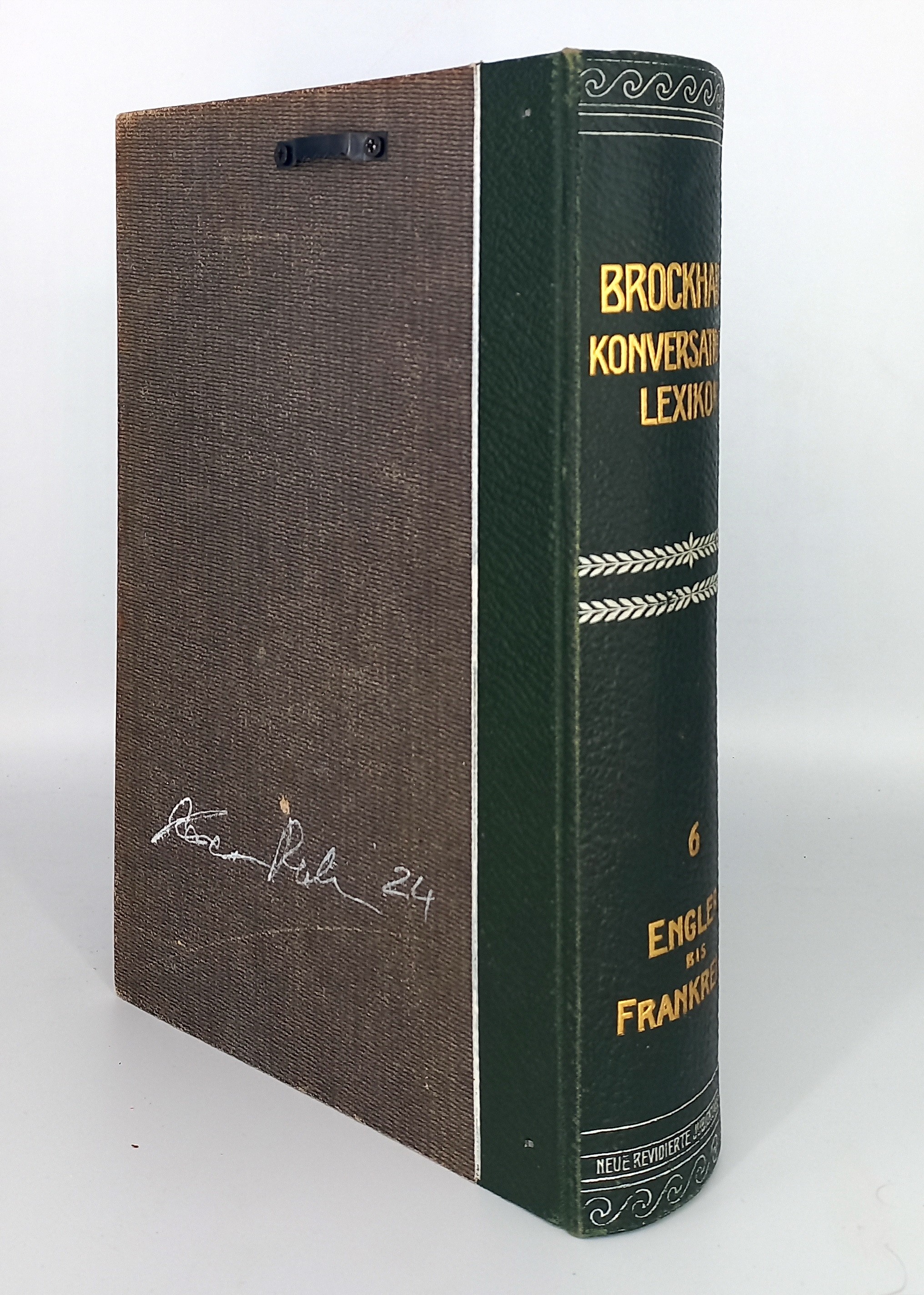 A book with a brown cover sitting on top of a white table.