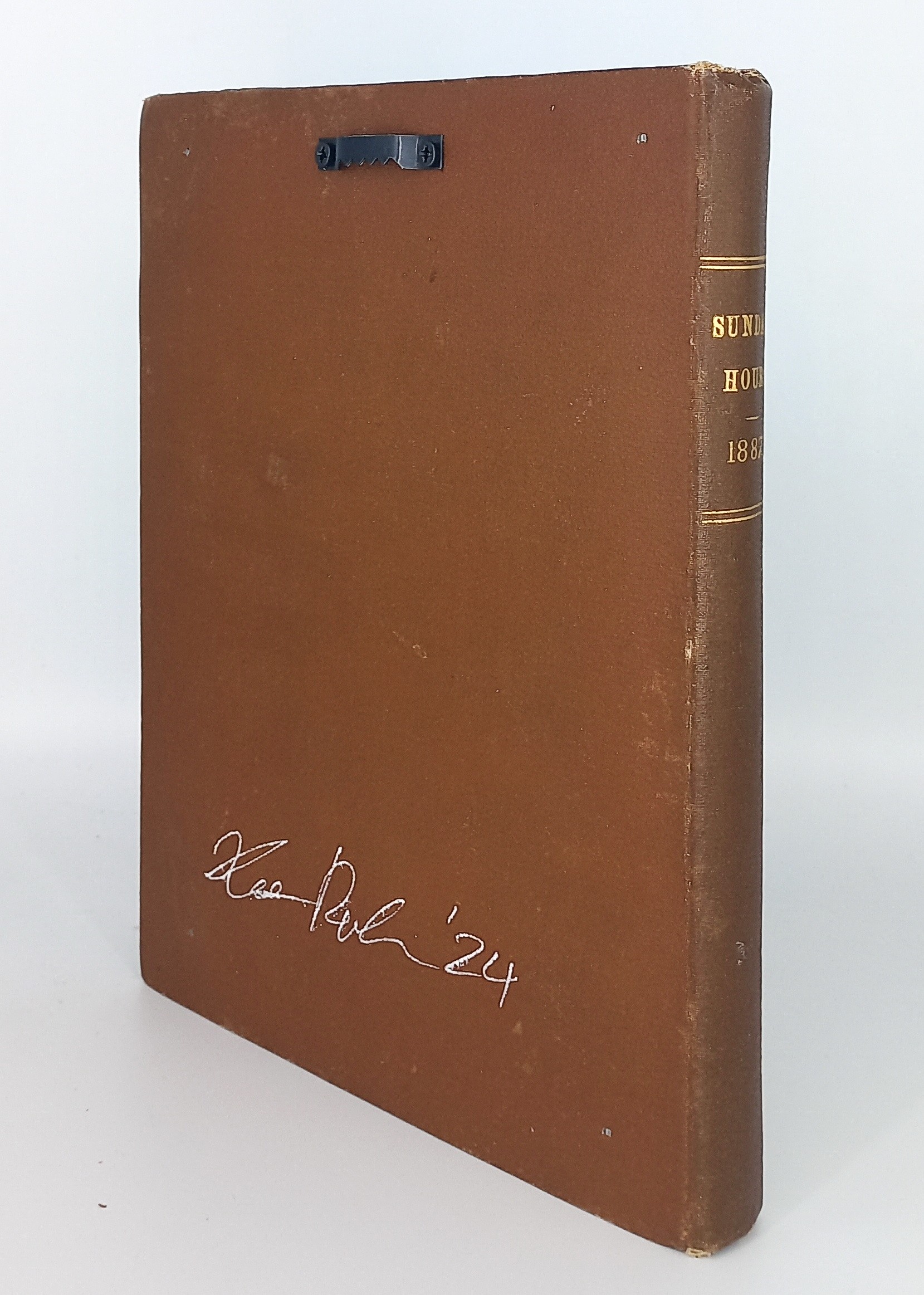 A brown book with a black pen on top of it.