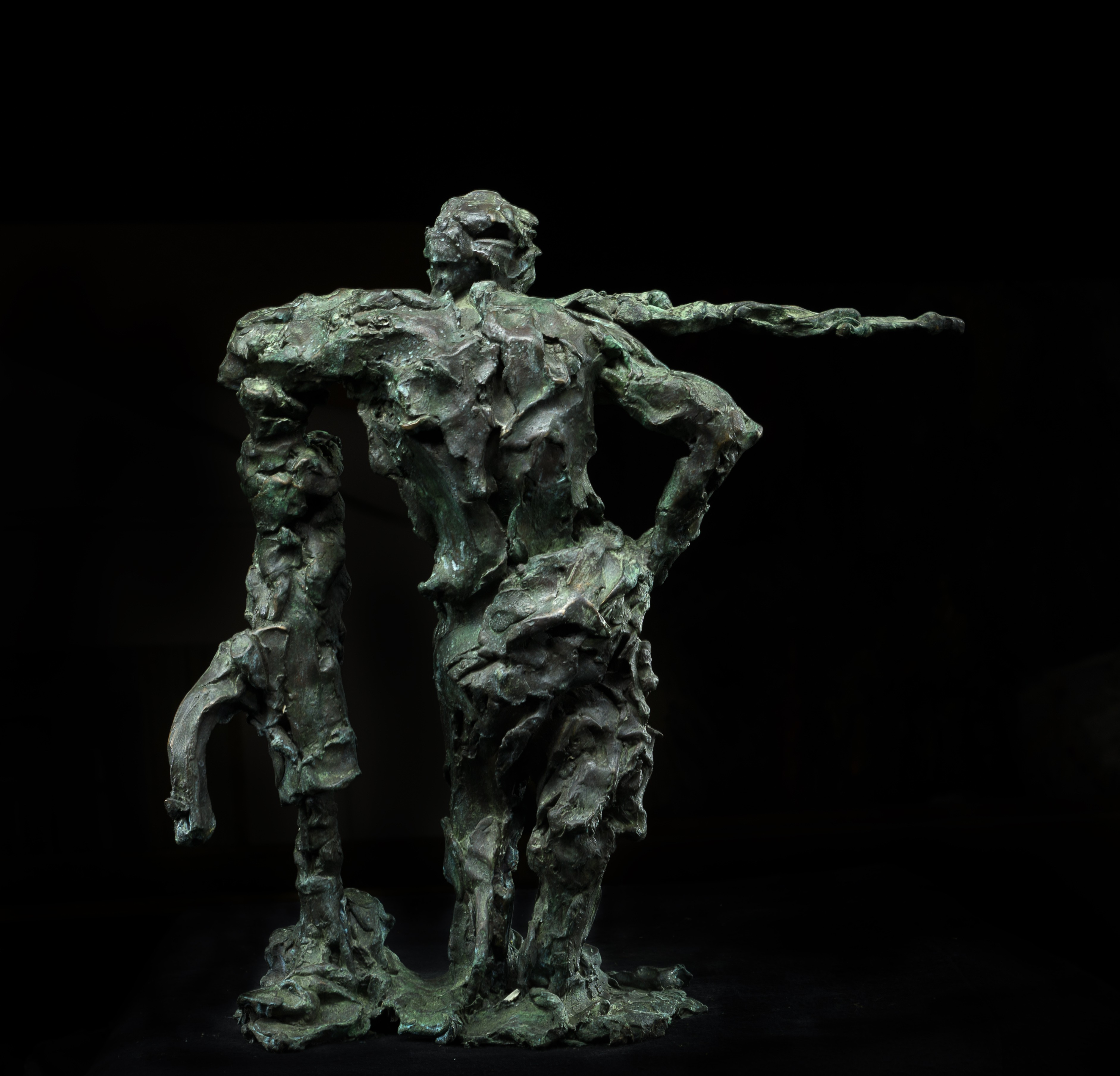 A bronze sculpture of a man holding a stick.